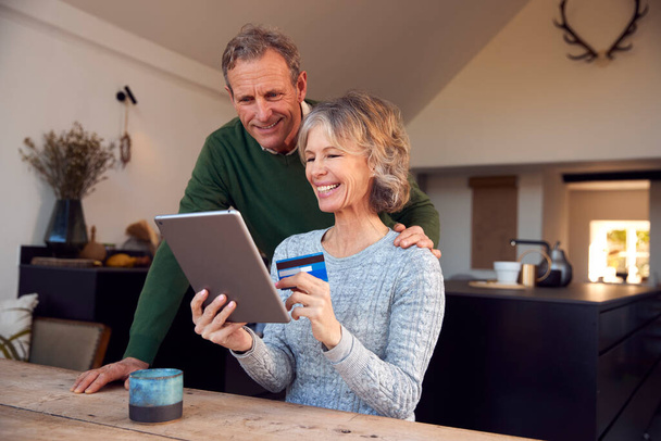 Retired Senior Couple At Home Buying Products Or Services Online With Digital Tablet And Credit Card - Fotoğraf, Görsel