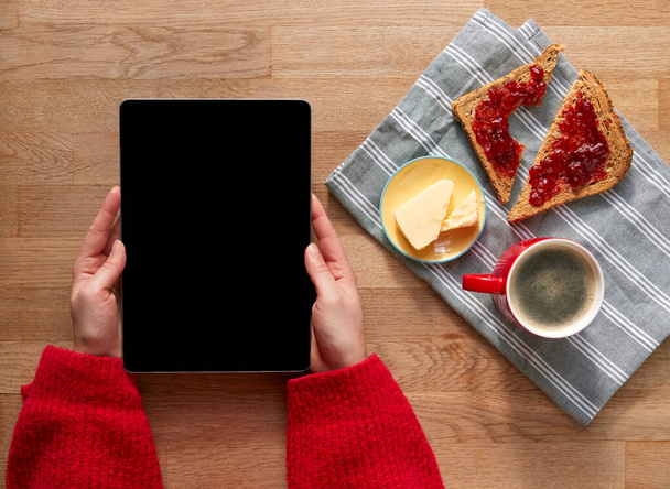 Overhead Flat Lay Of Woman With Digital Tablet On Table Laid For Breakfast With Croissant And Coffee - Fotoğraf, Görsel