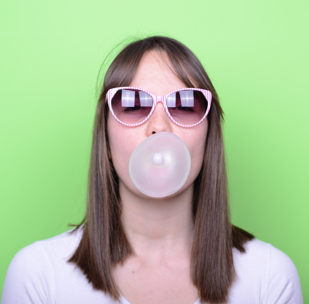 Portrait of girl with glasses making balloon with bubble gum - Fotoğraf, Görsel