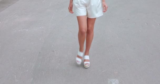 cropped view of woman in shorts and sandals walking on street - Footage, Video