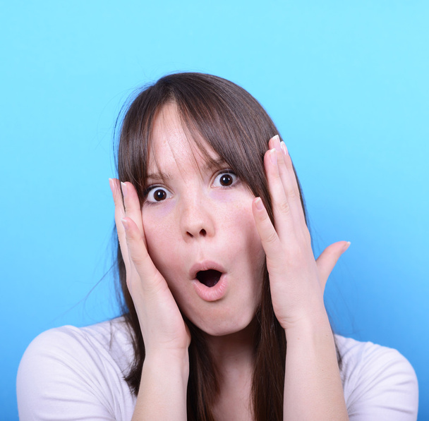 Portrait of girl with shock gesture against blue background - Photo, Image