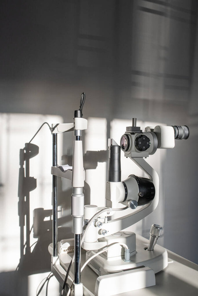 Ophthalmological diagnostic equipment on doctor workplace inside medical office of contemporary ophthalmic clinics or hospital - 写真・画像