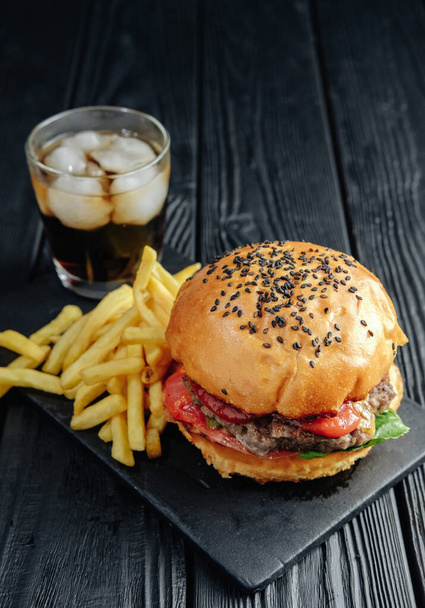 homemade juicy burger on dark wooden board. Street food, fast food - Foto, afbeelding