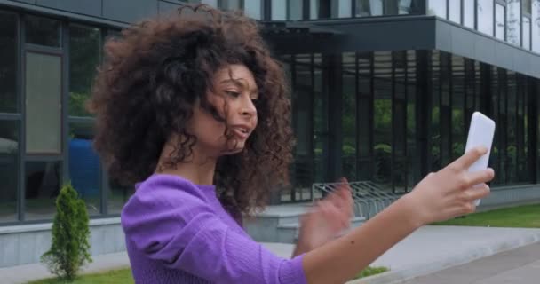 donna allegra sorridente e prendendo selfie vicino edificio  - Filmati, video