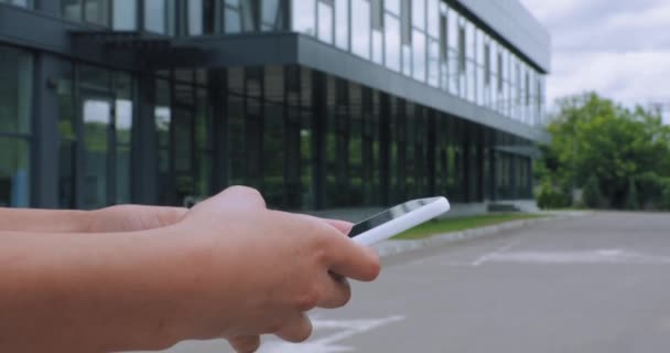 przycięty widok kobiety smsy na smartfonie na zewnątrz  - Materiał filmowy, wideo