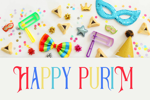Purim celebration concept (jewish carnival holiday) over wooden white background. Top view, flat lay - Foto, immagini