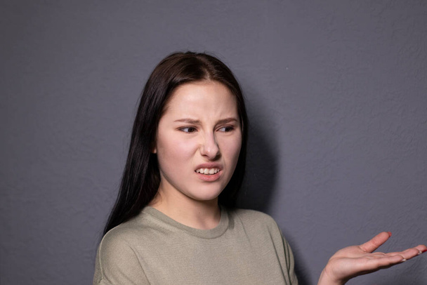 portrét okouzlující šokované brunetky žena v bažinaté barvě tričko na šedém pozadí stěny. herečka, emoce. kopírovat prostor - Fotografie, Obrázek