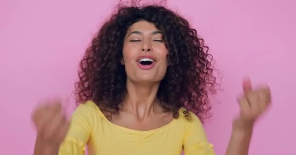 mujer joven emocionada celebrando triunfo aislado en rosa  - Metraje, vídeo