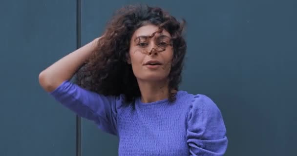 χαρούμενη γυναίκα προσαρμογή των μαλλιών και την αποστολή φιλί αέρα σε θυελλώδη καιρό έξω  - Πλάνα, βίντεο