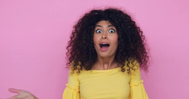 erstaunt junge Frau bedeckt Mund isoliert auf rosa  - Filmmaterial, Video