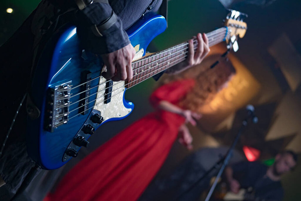 Bassgitarre in den Händen eines Musikers - Foto, Bild