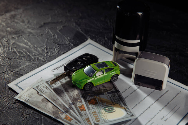 Koop- of huurcontract voor een auto met stempels, sleutels en speelgoedauto - Foto, afbeelding