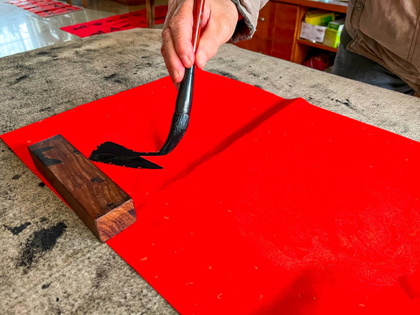 A calligrapher is creating and writing Spring Festival couplets, Chinese New Year Spring Festival. Translation: Spring is in many cities. - Photo, Image