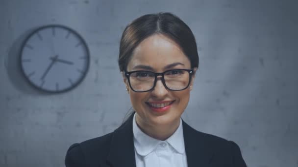 Glimlachende verzekeringsadviseur kijkt naar camera in kantoor  - Video