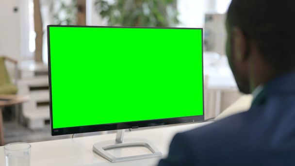 Geschäftsmann mit Desktop mit grünem Chroma-Schlüsselbildschirm  - Foto, Bild