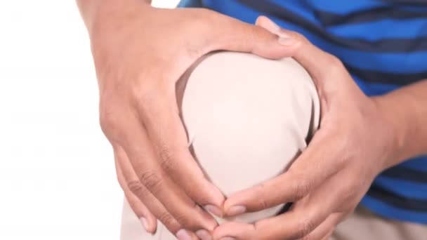  mladý muž trpí bolesti kolenních kloubů izolovaných na bílém  - Záběry, video
