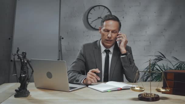 Agente de seguros falando no smartphone e usando laptop no escritório  - Filmagem, Vídeo