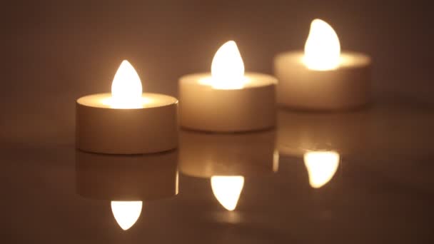 Três e-velas acesas em uma linha com reflexão em fundo escuro - Filmagem, Vídeo
