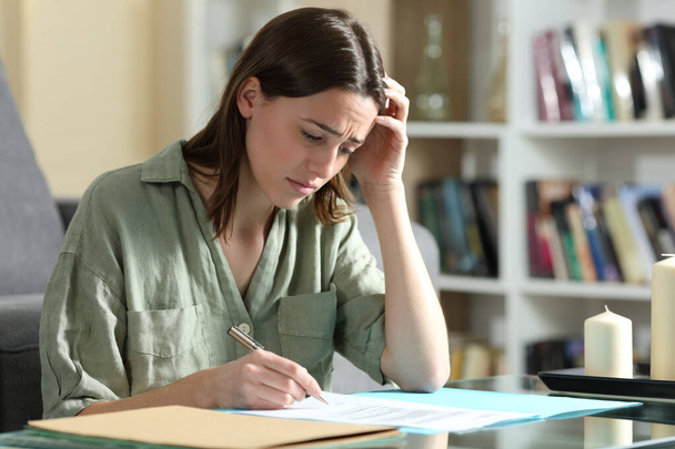 Sad woman ready to sign a contract complaining at home - Photo, Image