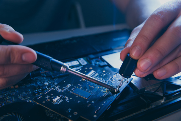 PC technology .Computer repair shop. Engineer performing laptop maintenance. Hardware developer fixing electronic components. - 写真・画像