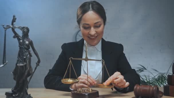 Usmívající se právník pomocí váhy a při pohledu do kamery v kanceláři  - Záběry, video