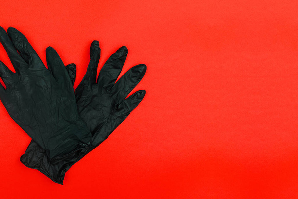 Jednorazowe rękawiczki na czerwonym tle z miejscem do kopiowania. Ochrona rąk przed bakteriami i wirusami - Zdjęcie, obraz