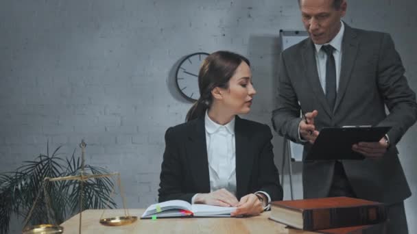 Anwalt gibt Kollegin am Arbeitstisch im Büro Klemmbrett  - Filmmaterial, Video