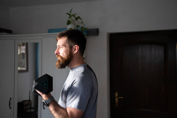 jóképű férfi gyakorló otthon emelés súlyok  - Fotó, kép