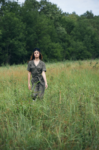 woman outdoors Green jumpsuit walk tall grass fresh air  - Valokuva, kuva