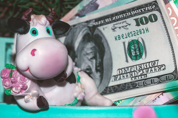 Statuetta in ceramica di un toro con banconote. Concetto: affari, finanza, toro, simbolo del 2021. Il simbolo del nuovo anno 2021. - Foto, immagini