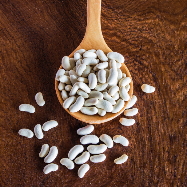 close up bean seed spoon on wood table - Valokuva, kuva