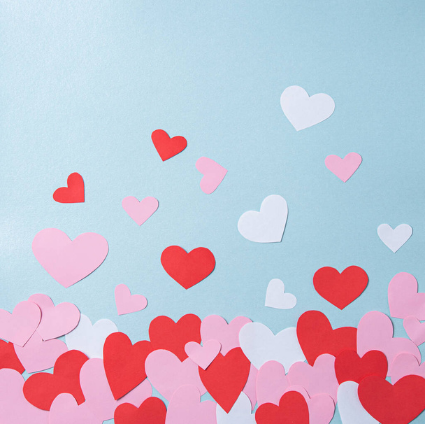 フラットパステルブルーの背景に赤、ピンクと白の心でレイアウト。バレンタインデーのコンセプト。トップ表示 - 写真・画像