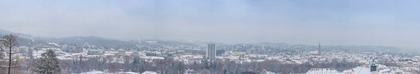 Cityscape of Graz with Church of the Sacred Heart of Jesus and historic buildings rooftops with snow, in Graz, Styria region, Austria, in winter - Photo, Image