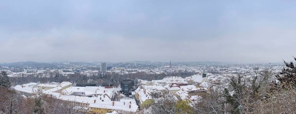 Městská krajina Štýrského Hradce s kostelem Nejsvětějšího Srdce Ježíše a historickými budovami střech se sněhem, v zimě v Štýrském Hradci, Rakousko - Fotografie, Obrázek