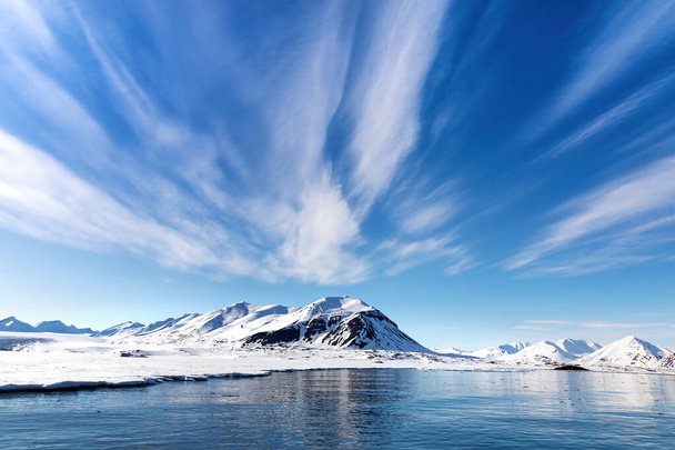 Kék ég, tenger és havas hegyek a gyönyörű fjordok Svalbard, egy norvég szigetcsoport között szárazföldi Norvégia és az Északi-sark - Fotó, kép