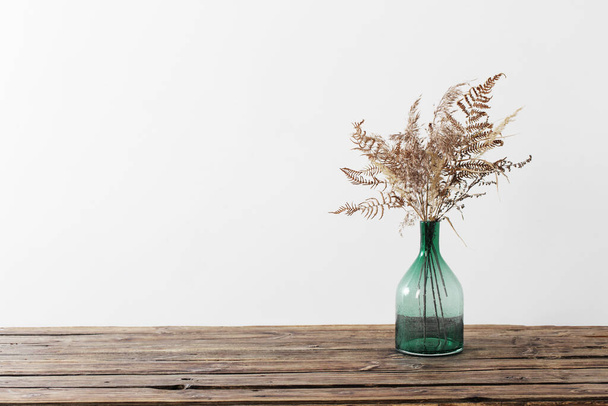 dried flowers in vase on wooden table on white background - Foto, Bild