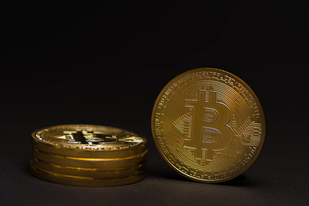 stack of golden shiny valuable bitcoin standing on a black background detail view - Zdjęcie, obraz