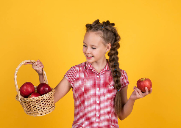 teen girl carry apples in basket. autumn harvest. spring season fruits. full of vitamins. organic food only. natural and healthy. happy childhood. kid eat apple. child with fruit - Fotó, kép