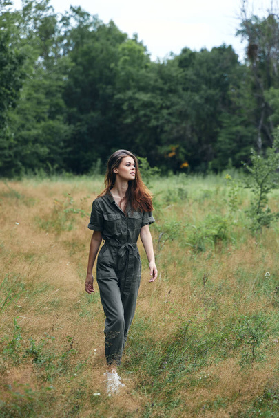 Žena v lese suchá tráva šedá kombinéza  - Fotografie, Obrázek