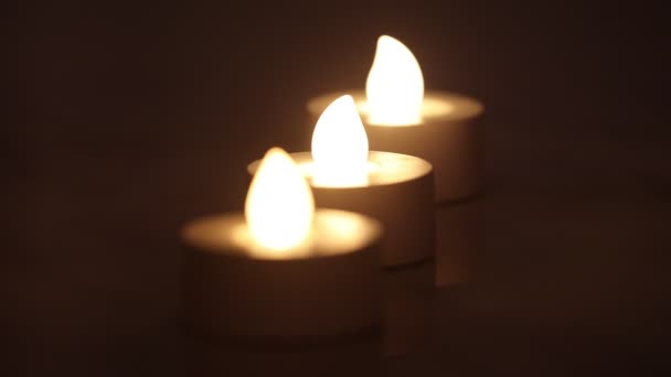 Três e-velas acesas em uma linha com fundo escuro - Filmagem, Vídeo