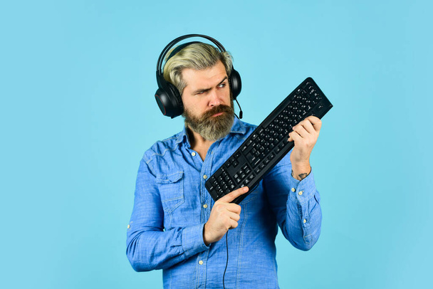Online gaming. Gaming modern leisure. Cyber sport arena. Tech shop. Play computer games. Man bearded hipster gamer headphones and keyboard. Gaming PC build guide. Graphics settings. Gaming addiction - Fotó, kép