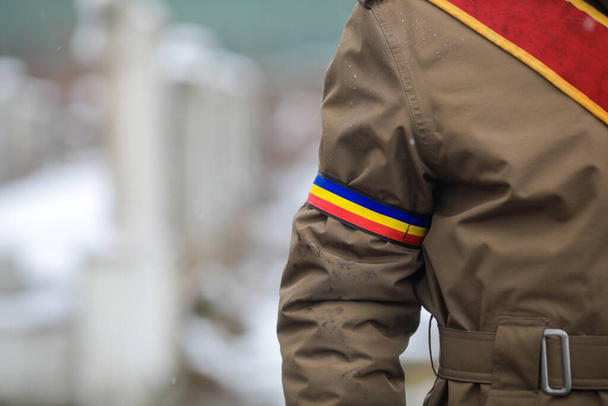 Mělká hloubka pole (selektivní zaměření) s uniformou rumunského vojáka během oficiálního obřadu v chladném a zasněženém zimním dni. - Fotografie, Obrázek