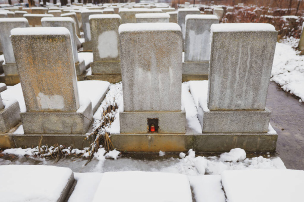 Soğuk ve karlı bir kış gününde Yahudi mezarlığında mezar taşları. - Fotoğraf, Görsel