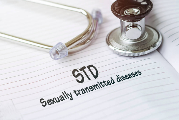 STD - sexually transmitted diseases. Text on a medical card next to a pen stethoscope. - Foto, afbeelding
