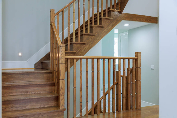 В строящемся доме устанавливают деревянные перила для лестниц - Фото, изображение