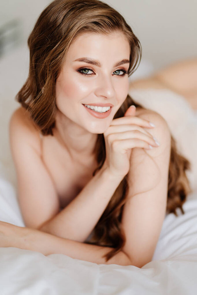 close up. portrait of beautiful woman with long hair in underwear lying on bed. - Φωτογραφία, εικόνα