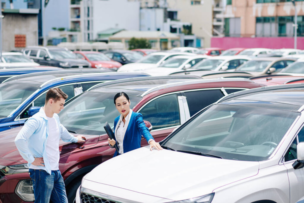 Menedżer sprzedaży kobiet pomaga klientowi wybrać nowy samochód - Zdjęcie, obraz