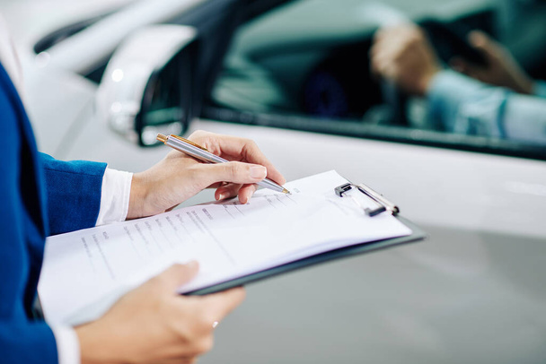 Gerente de concesionarios llenando la información del cliente cuando el cliente prueba conducir un coche antes de comprarlo - Foto, imagen
