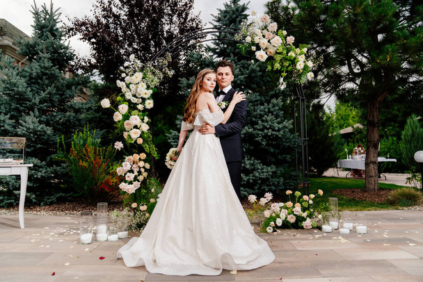 outdoor wedding ceremony in an arch of living flowers.Beautiful couple newlyweds - Foto, Bild