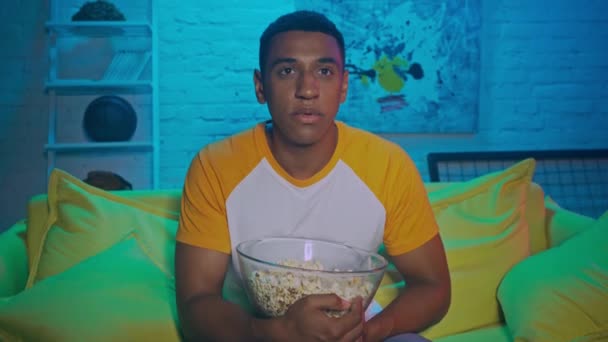 Afro-Amerikaanse man met popcorn kijken tv  - Video